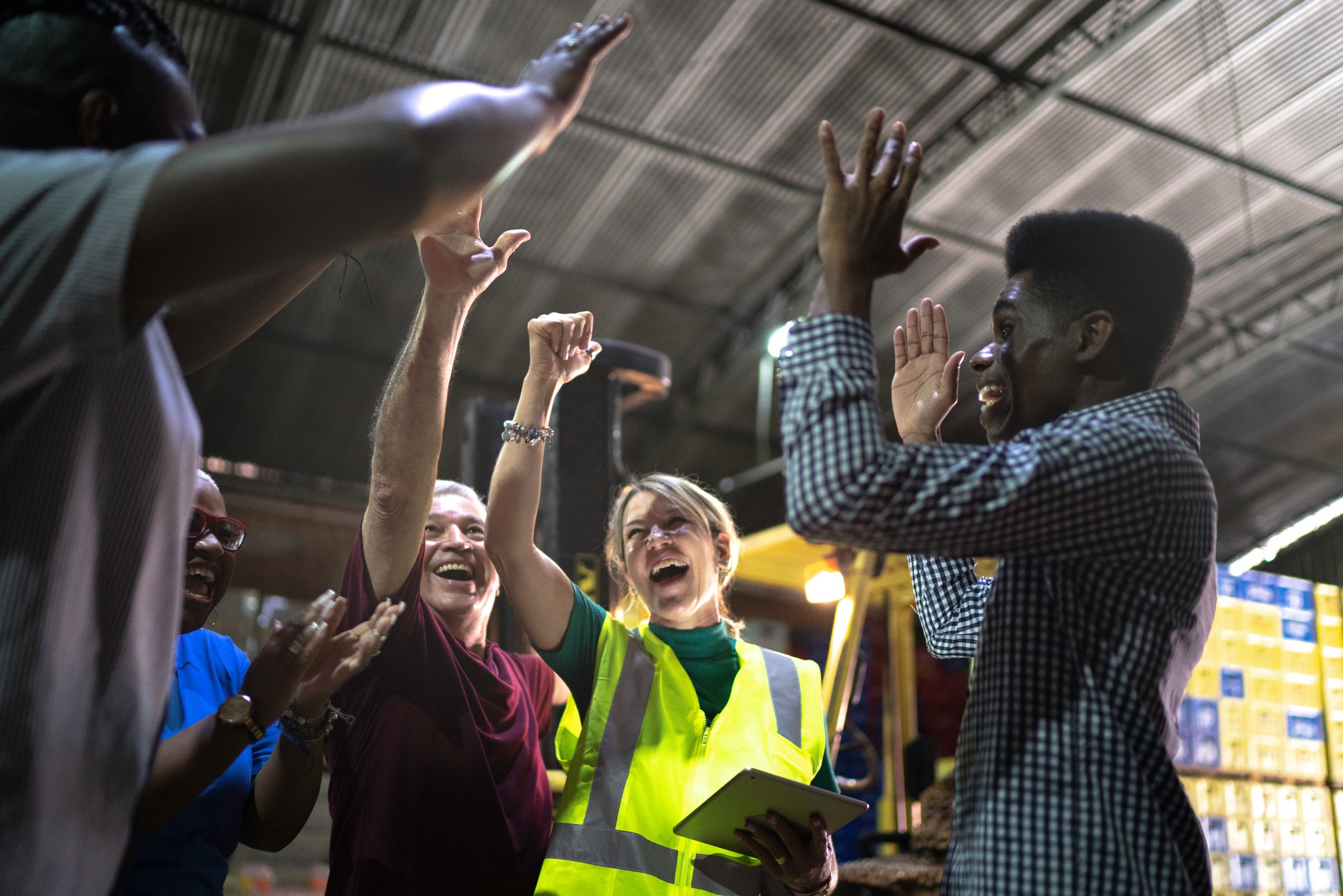 Happy employees celebrating together at warehouse